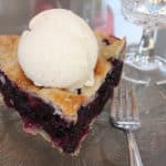 the best blueberry pie recipe with a scoop of vanilla ice cream on top